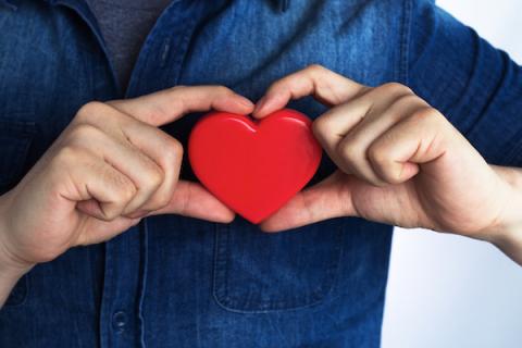 Heart disease and hearing man holding a heart